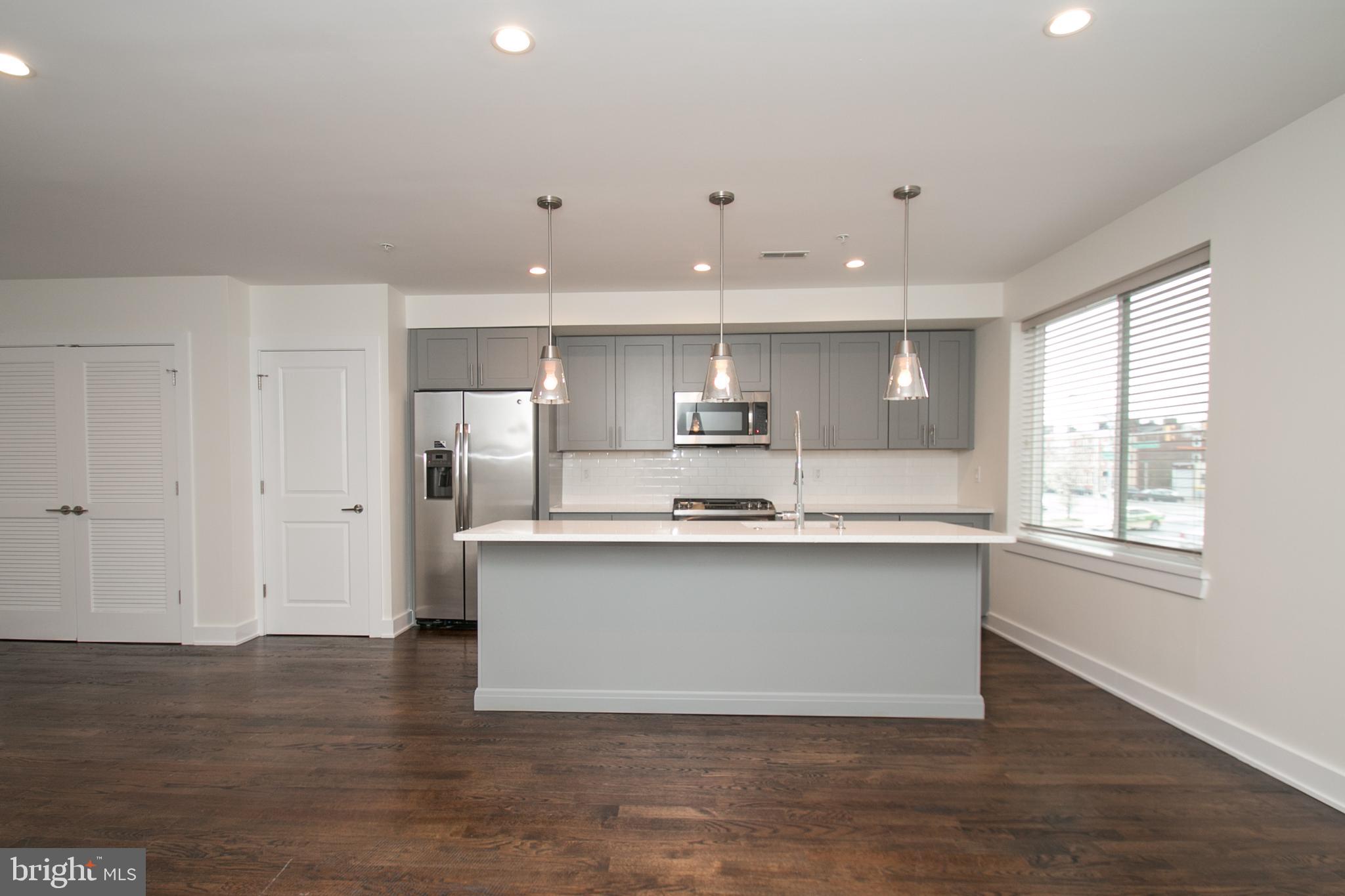 1022-24 South 2nd Street, Unit 4 Philadelphia, PA 19147 - Photo 4 of 50 a large kitchen with stainless steel appliances a large counter top a sink and a window