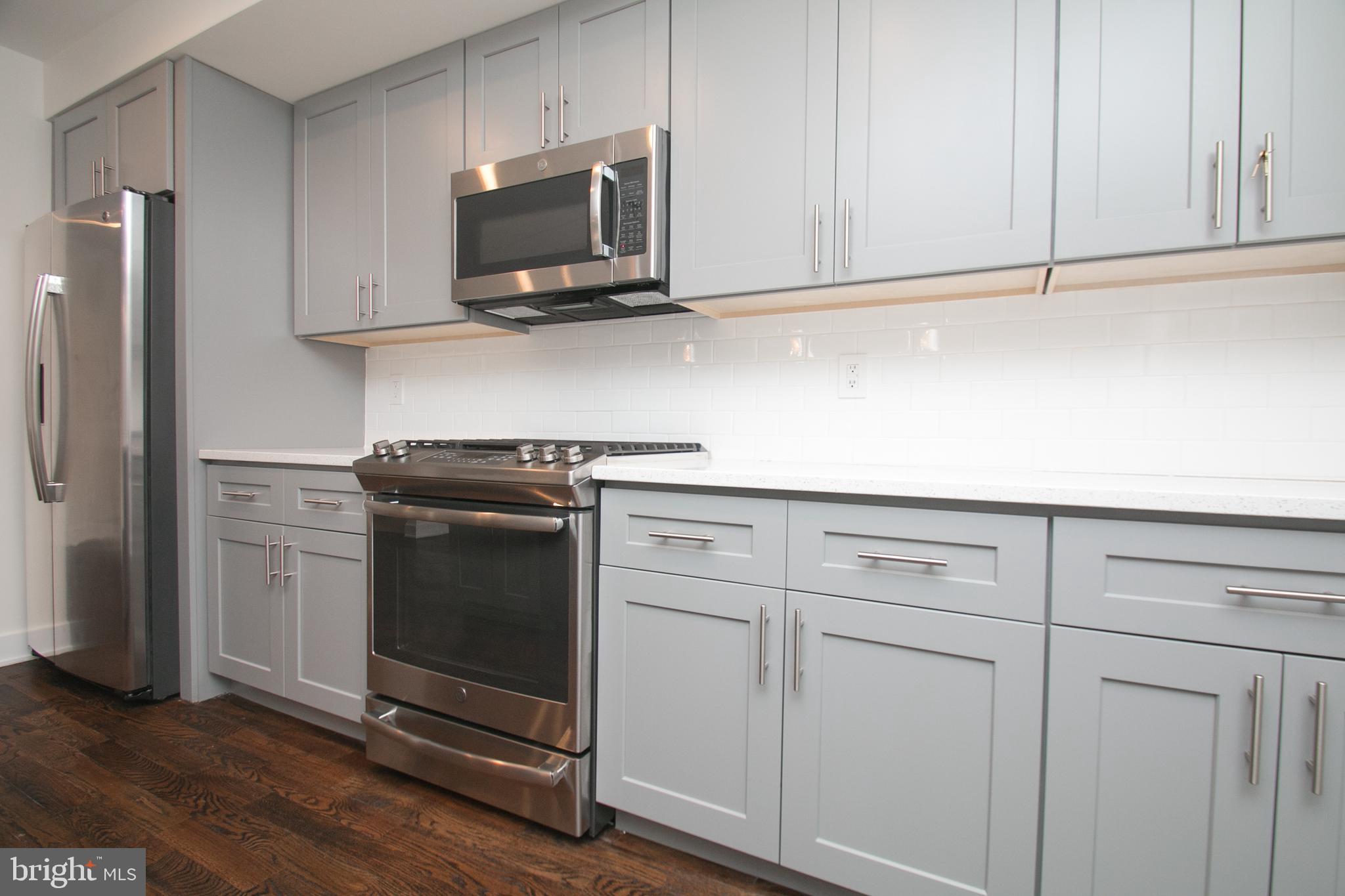 1022-24 South 2nd Street, Unit 4 Philadelphia, PA 19147 - Photo 6 of 50 a kitchen with white cabinets and stainless steel appliances