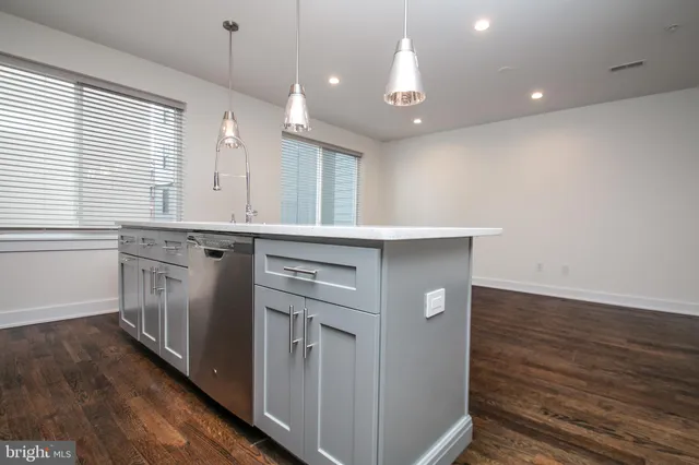 a kitchen with a sink cabinets and wooden floor