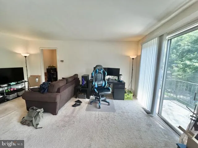 a view of a livingroom with workspace and a window