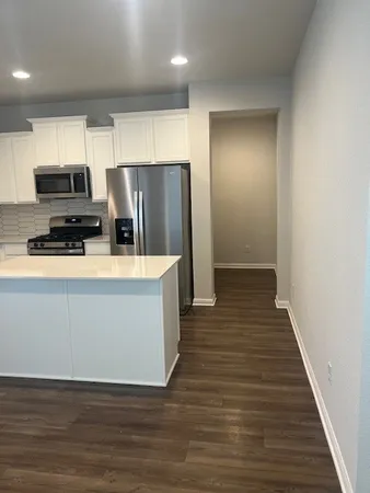 a kitchen with stainless steel appliances a refrigerator and a stove top oven