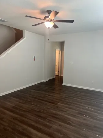 a view of an empty room with wooden floor