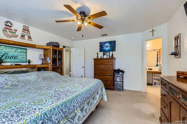a bedroom with a bed and a large mirror on the dresser