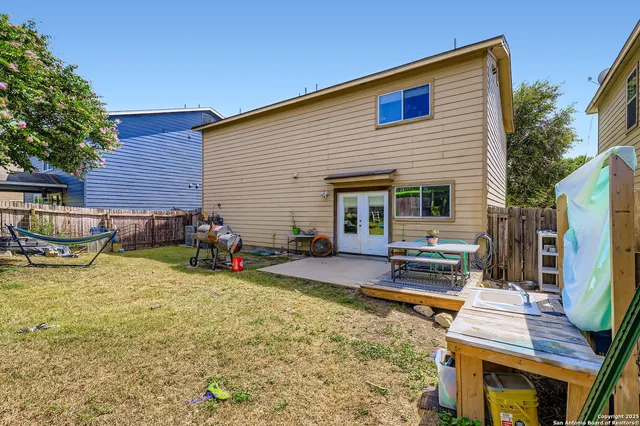 a view of a house with a patio and a yard