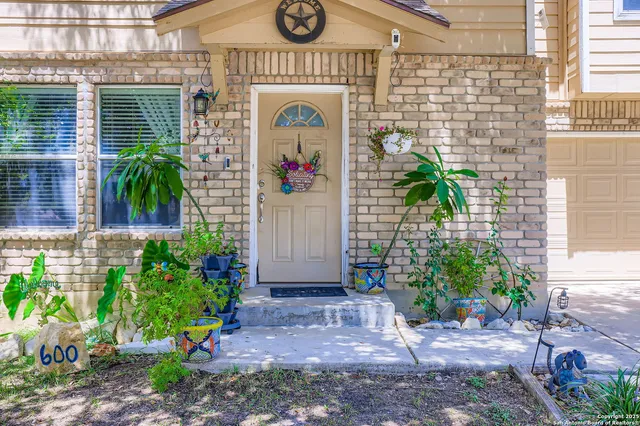 a front view of a house with potted plants