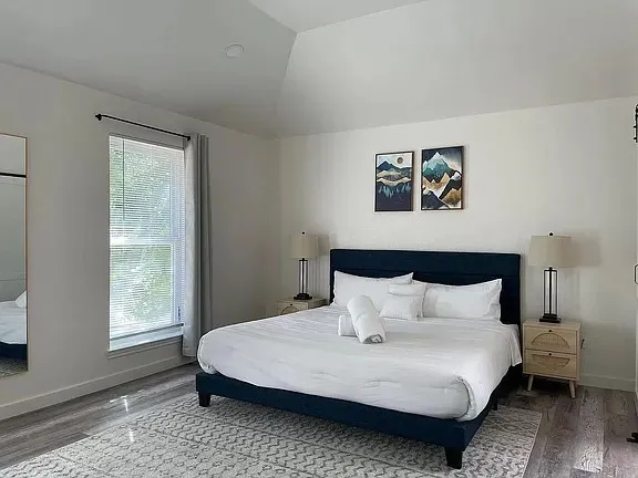 a bedroom with a bed and painting on the wall