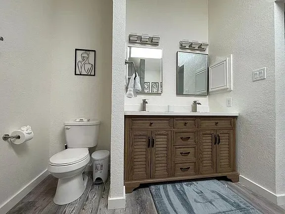 a bathroom with a double vanity sink mirror and bathtub