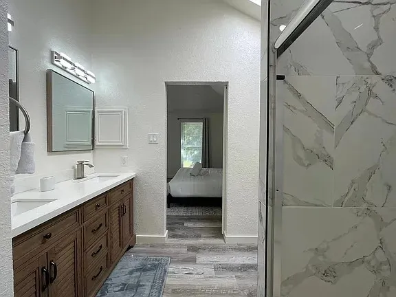 a bathroom with a granite countertop sink and a mirror