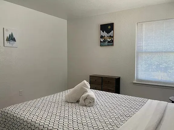 a bed room with a bed and painting on the wall