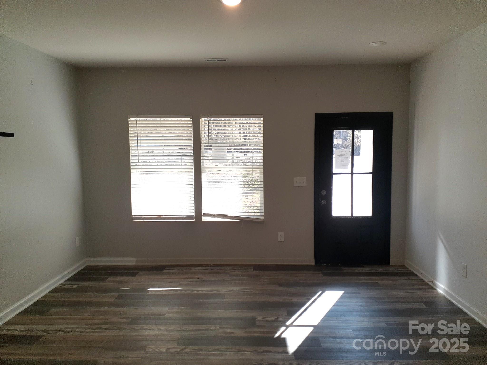3944 Wade E Morgan Road Charlotte, NC 28269 - Photo 5 of 20 an empty room with wooden floor and windows