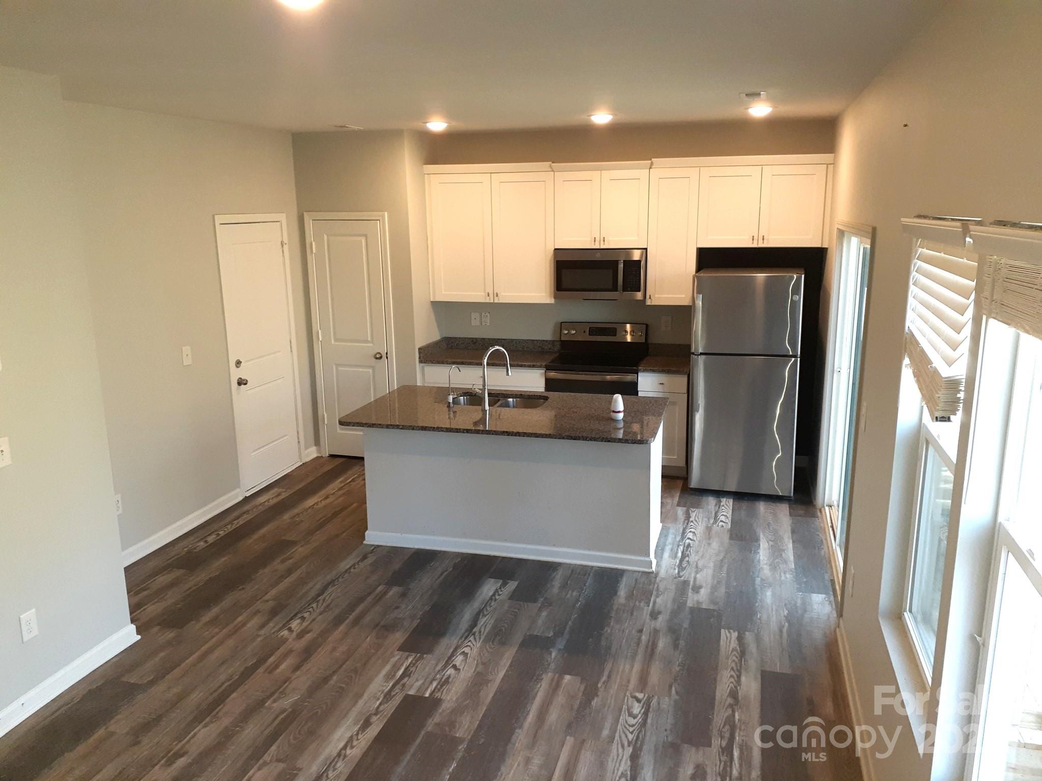 3944 Wade E Morgan Road Charlotte, NC 28269 - Photo 7 of 20 a kitchen with stainless steel appliances a refrigerator and a stove top oven