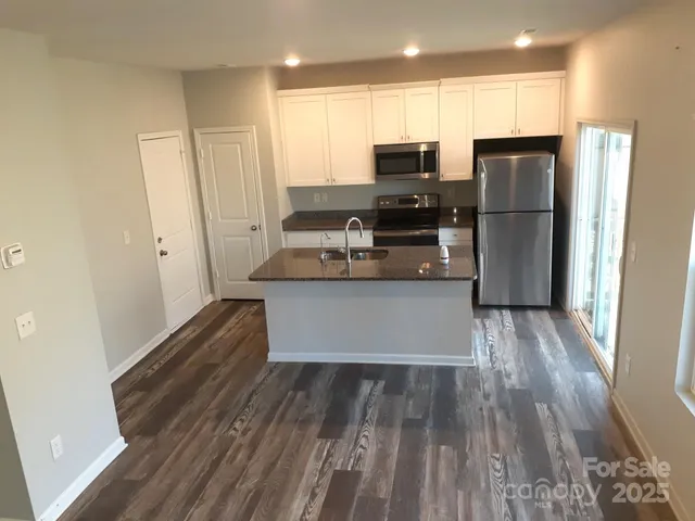 a kitchen with stainless steel appliances a refrigerator and a stove top oven