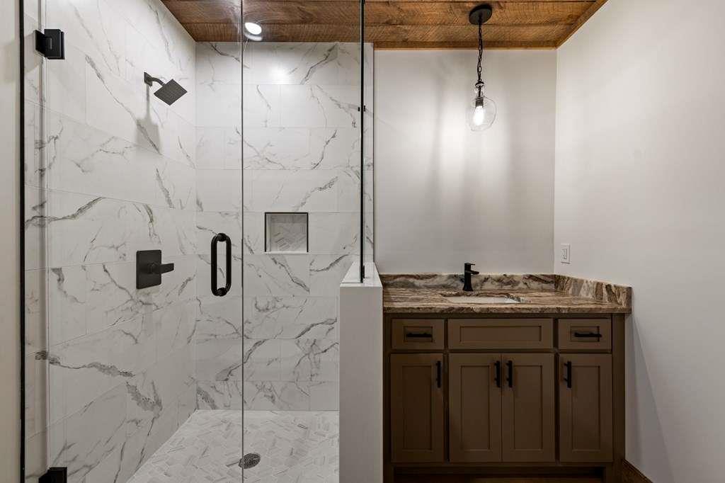 2393 Ada Street Blue Ridge, GA 30513 - Photo 40 of 56 a bathroom with a granite countertop sink a shower and mirror