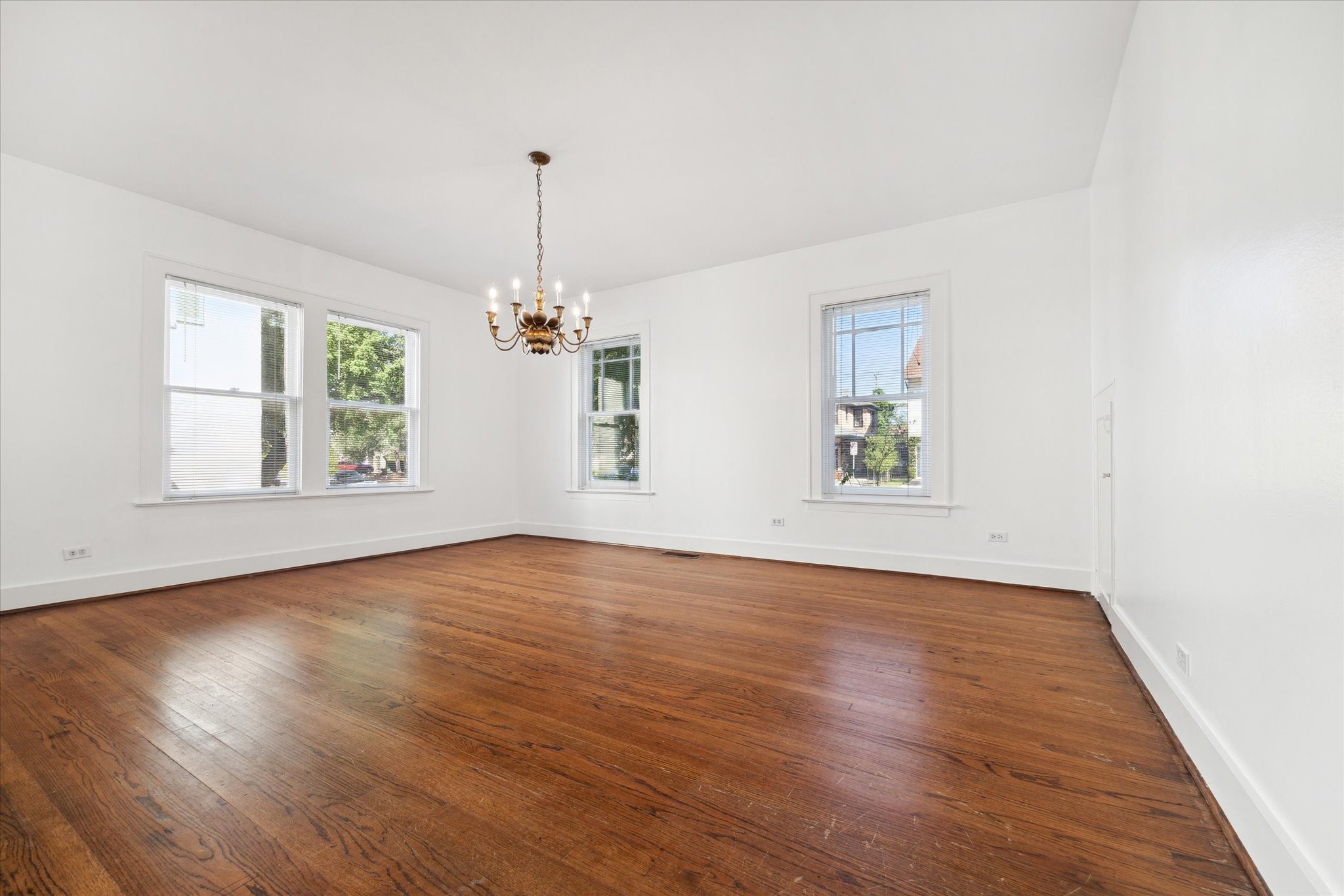 2309 Wroxton Road Houston, TX 77005 - Photo 14 of 15 an empty room with wooden floor chandelier and windows
