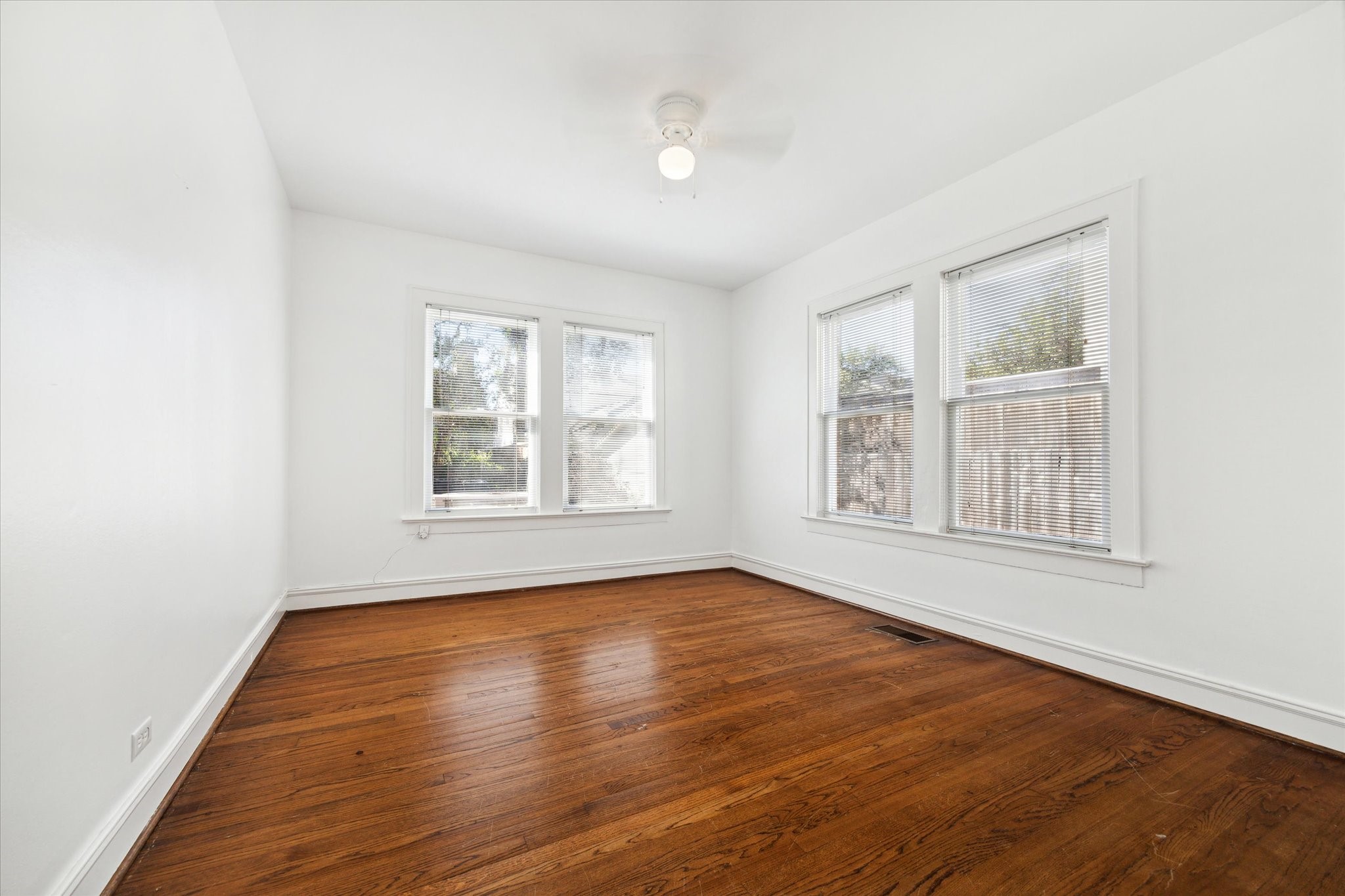 2309 Wroxton Road Houston, TX 77005 - Photo 5 of 15 an empty room with wooden floor and windows