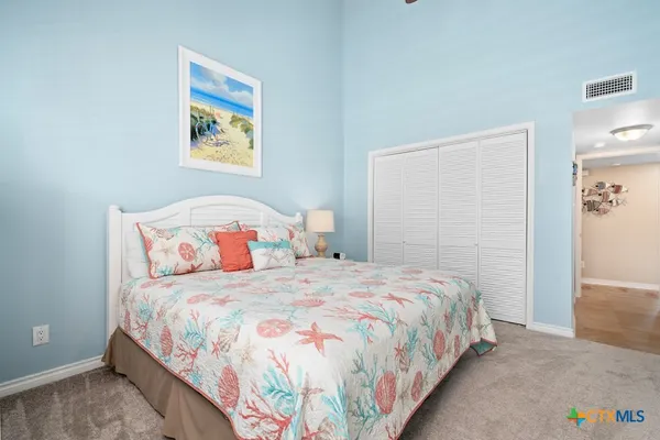 a bedroom with a bed and painting on the wall