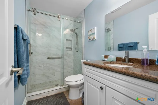 a bathroom with a granite countertop sink toilet and shower
