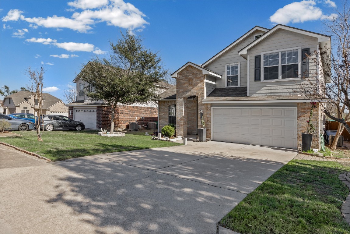 1321 Bunratty Circle Pflugerville, TX 78660 - Photo 2 of 31 Traditional-style house with concrete driveway, a front lawn, stone siding, a residential view, and a garage