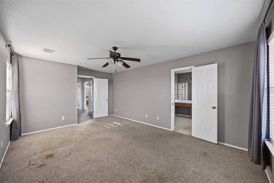 1321 Bunratty Circle Pflugerville, TX 78660 - Photo 21 of 31 Unfurnished bedroom featuring carpet floors, ceiling fan, and ensuite bathroom