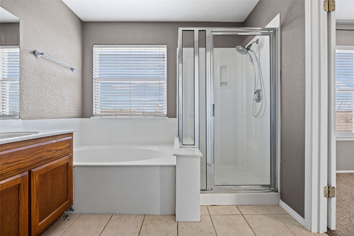 1321 Bunratty Circle Pflugerville, TX 78660 - Photo 23 of 31 Full bath with a shower stall, a bath, a textured wall, vanity, and light tile patterned floors
