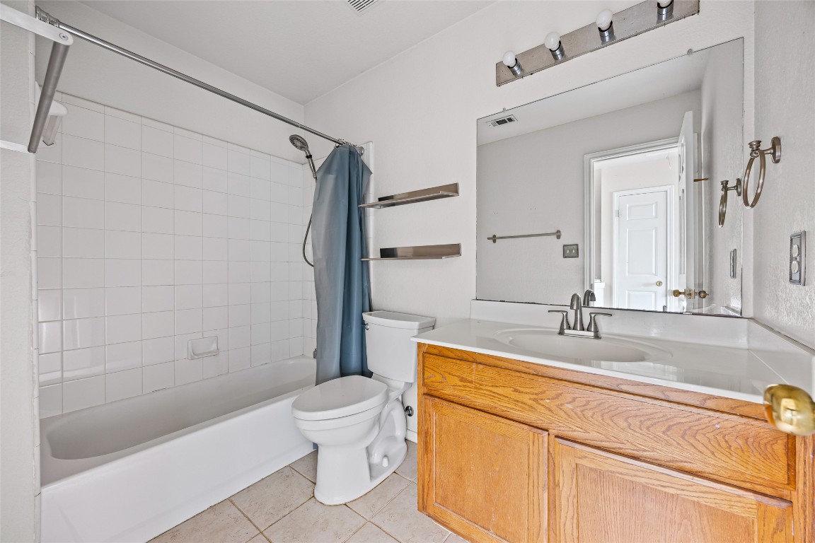1321 Bunratty Circle Pflugerville, TX 78660 - Photo 24 of 31 Full bathroom featuring vanity, shower / bathtub combination with curtain, and light tile patterned floors