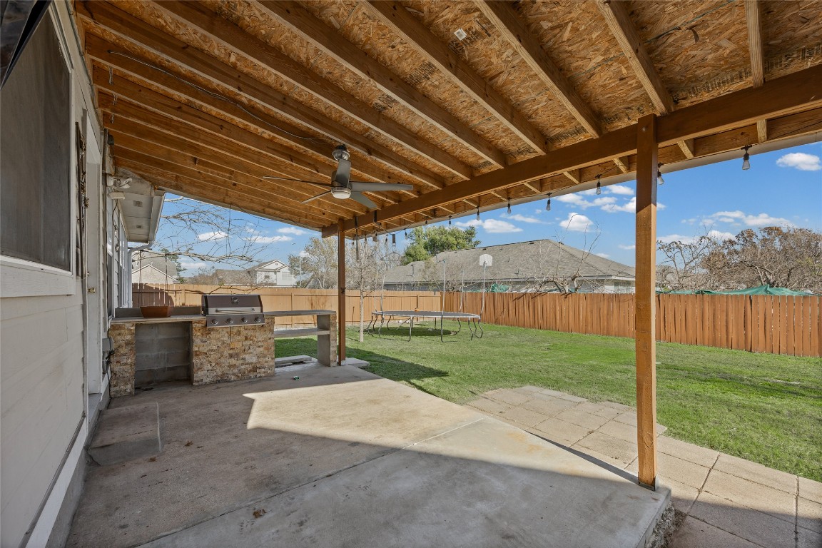 1321 Bunratty Circle Pflugerville, TX 78660 - Photo 30 of 31 Fenced backyard with a patio, a trampoline, a ceiling fan, and exterior kitchen