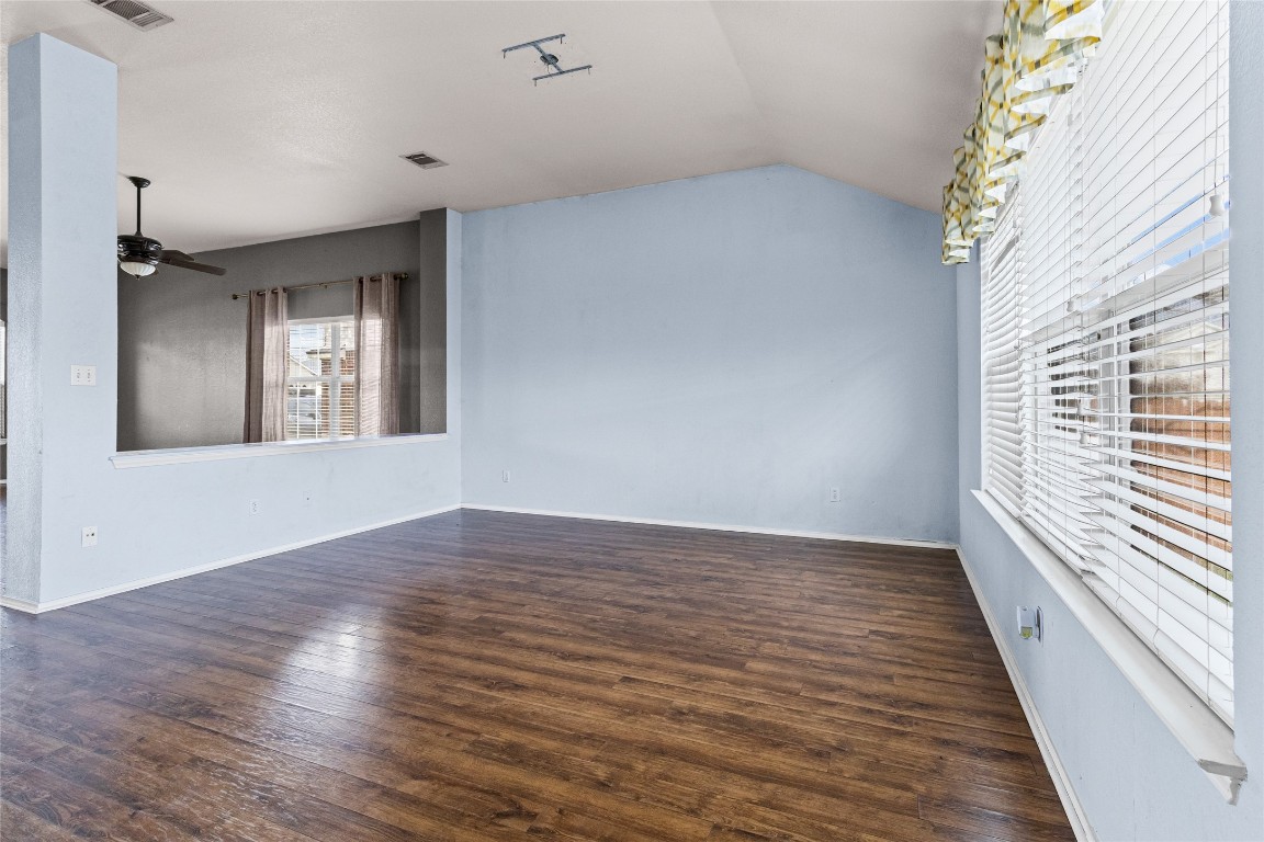 1321 Bunratty Circle Pflugerville, TX 78660 - Photo 5 of 31 Unfurnished room featuring lofted ceiling, dark wood finished floors, and ceiling fan