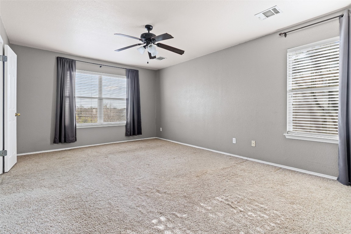 1321 Bunratty Circle Pflugerville, TX 78660 - Photo 9 of 31 Unfurnished room with light colored carpet, ceiling fan, and healthy amount of natural light