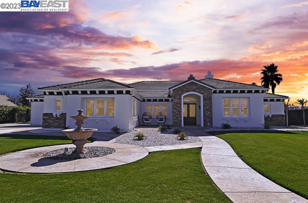a front view of a house with a yard garden and seating area