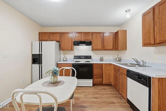 a kitchen with stainless steel appliances granite countertop a kitchen island a stove a sink a dining table and chairs