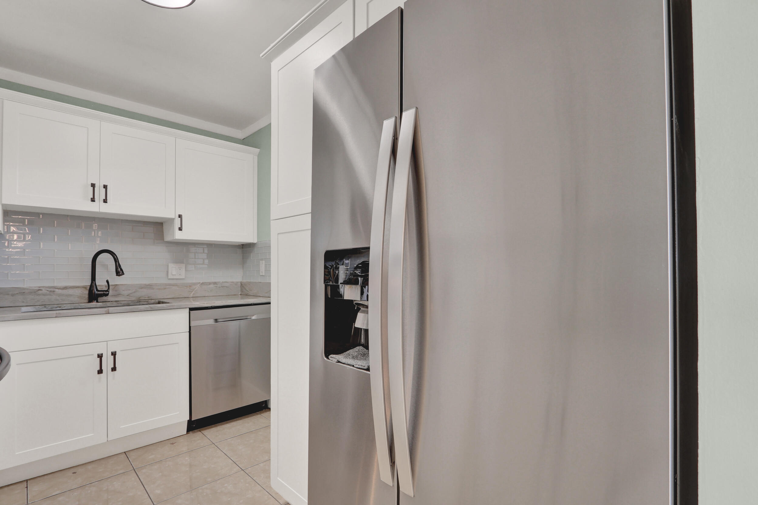 502 Davis Road, Unit 12 Palm Springs, FL 33461 - Photo 11 of 23 a kitchen with stainless steel appliances granite countertop a sink and a refrigerator