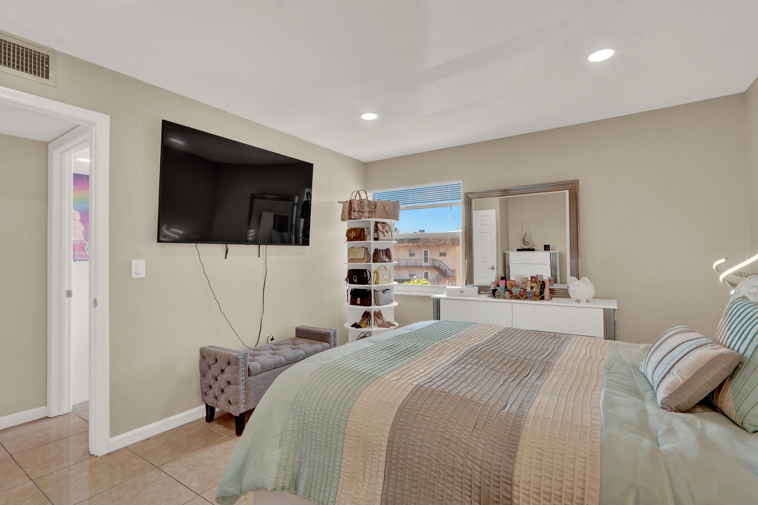 502 Davis Road, Unit 12 Palm Springs, FL 33461 - Photo 12 of 23 a bedroom with a bed a television and a large window