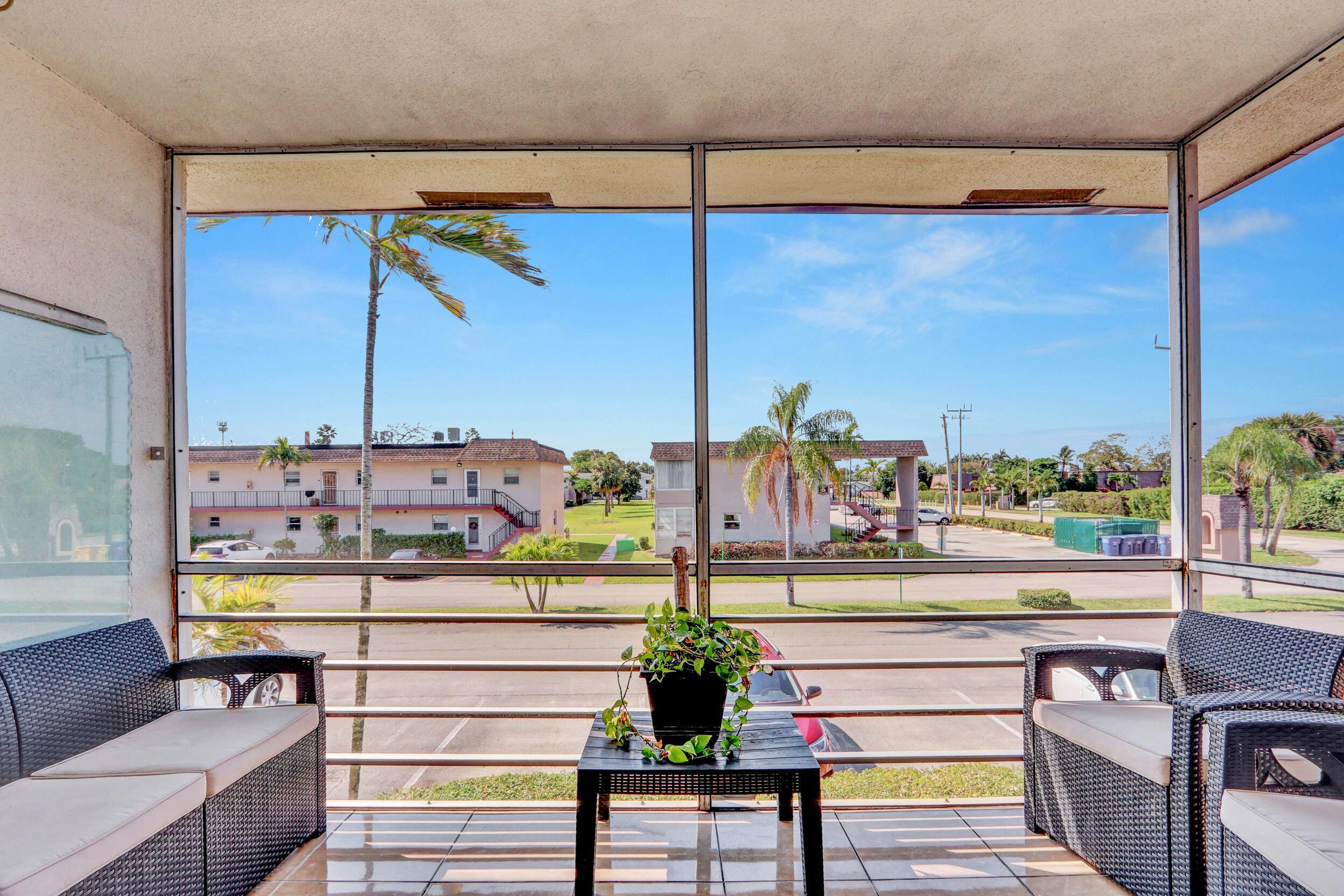 502 Davis Road, Unit 12 Palm Springs, FL 33461 - Photo 5 of 23 a view of a balcony with chairs and a potted plant