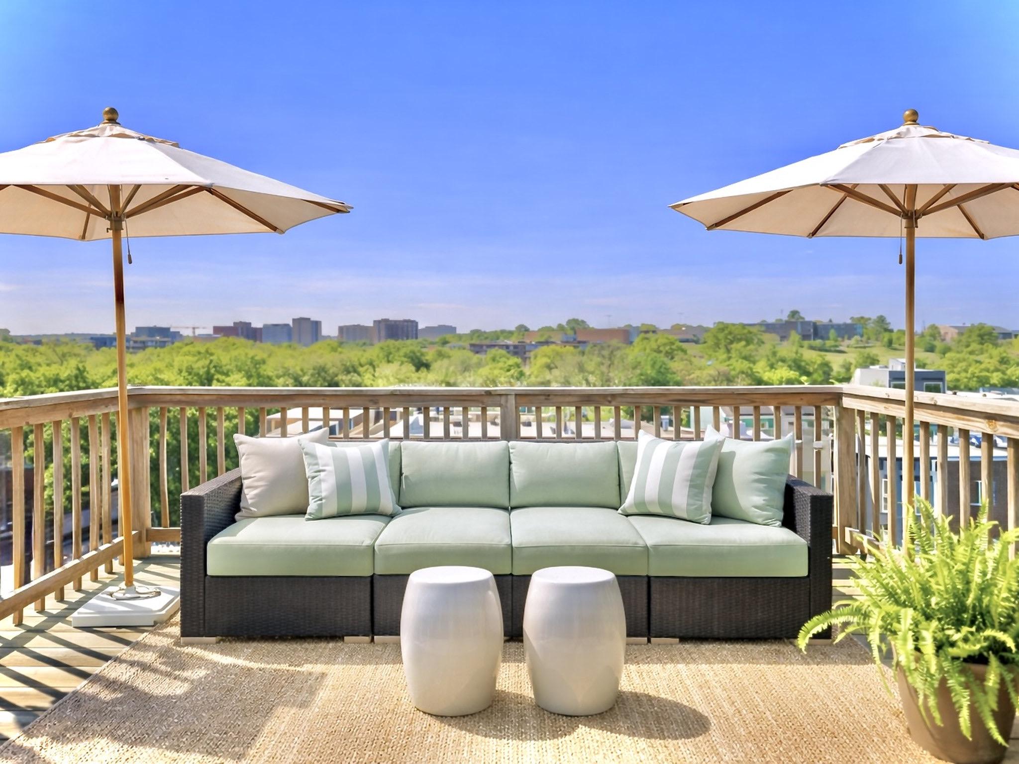 a view of a balcony with furniture and an umbrella