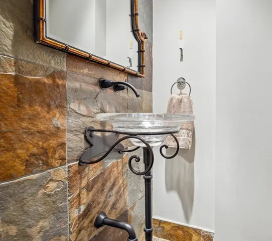 a bathroom with a granite countertop sink a toilet and mirror