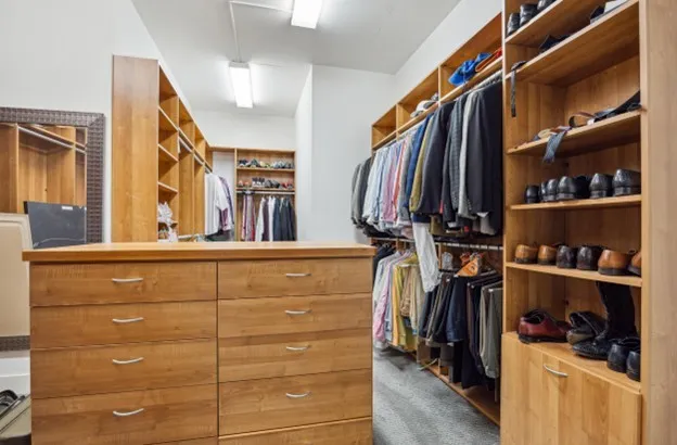 a view of walk in closet with clothes and shoes