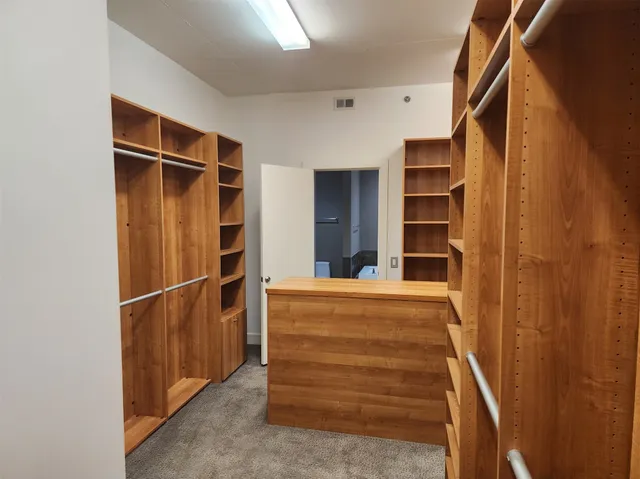 a view of walk in closet with empty racks