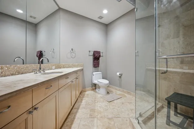 a bathroom with a double vanity sink toilet and shower