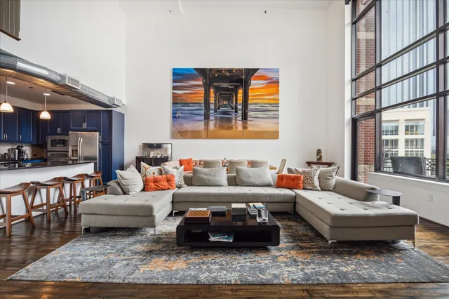 a living room with furniture wooden floor and a large window