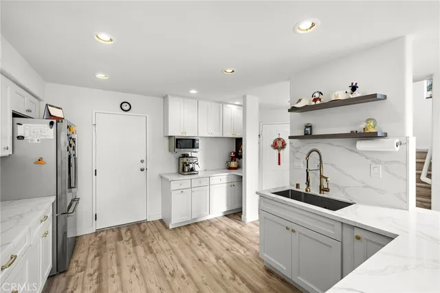 a kitchen with stainless steel appliances a refrigerator sink and wooden cabinets