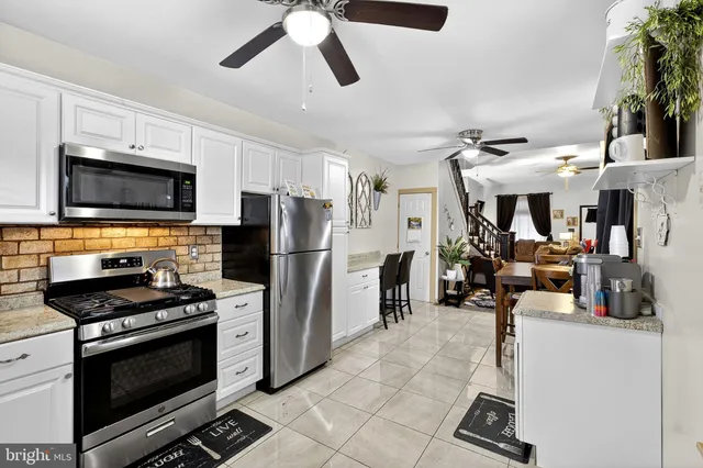 a kitchen with stainless steel appliances kitchen island granite countertop a stove and a sink