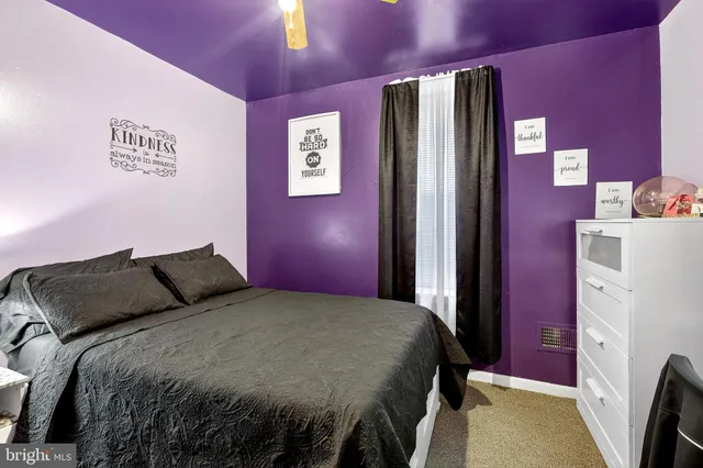 a bedroom with a bed and a refrigerator