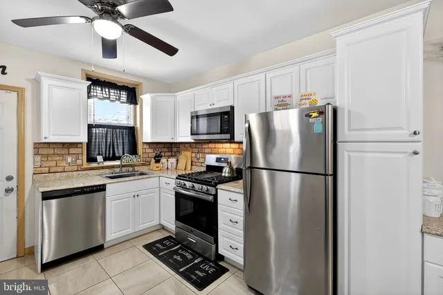 a kitchen with stainless steel appliances a refrigerator sink and stove