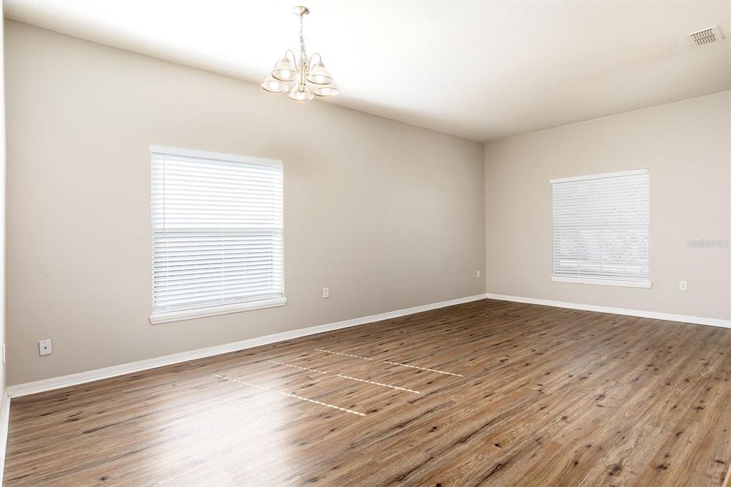 5255 Shale Ridge Trail Orlando, FL 32818 - Photo 12 of 24 an empty room with wooden floor and windows