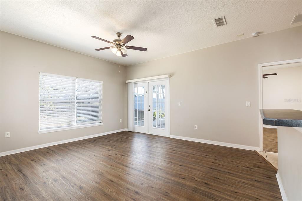 5255 Shale Ridge Trail Orlando, FL 32818 - Photo 5 of 24 a view of an empty room with wooden floor and a window