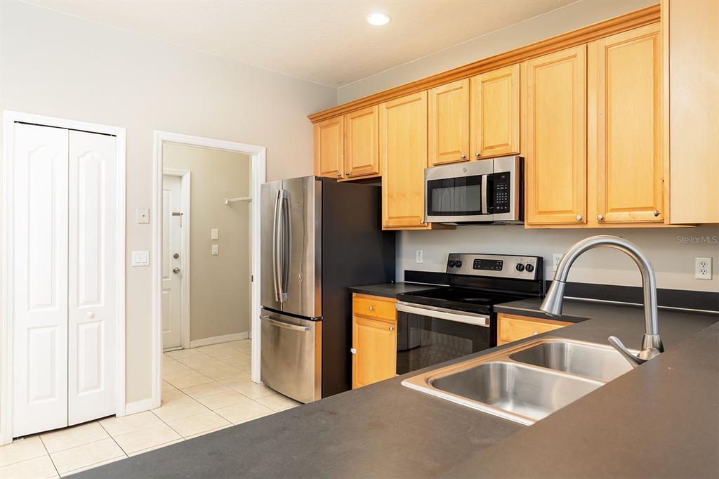 5255 Shale Ridge Trail Orlando, FL 32818 - Photo 10 of 24 a kitchen with stainless steel appliances granite countertop a refrigerator sink and microwave