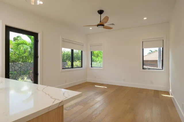 an empty room with a window and ceiling fan