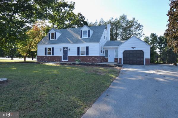 a front view of a house with a yard and trees