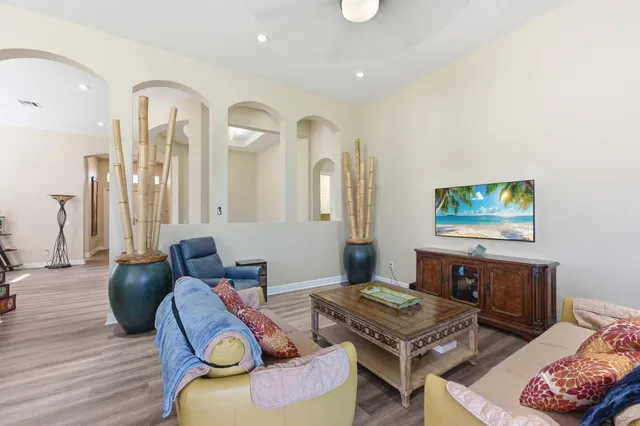 a living room with furniture a flat screen tv and kitchen view