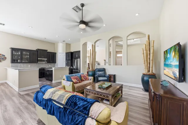 a kitchen with stainless steel appliances granite countertop a stove top oven a refrigerator a sink and dishwasher with wooden floor